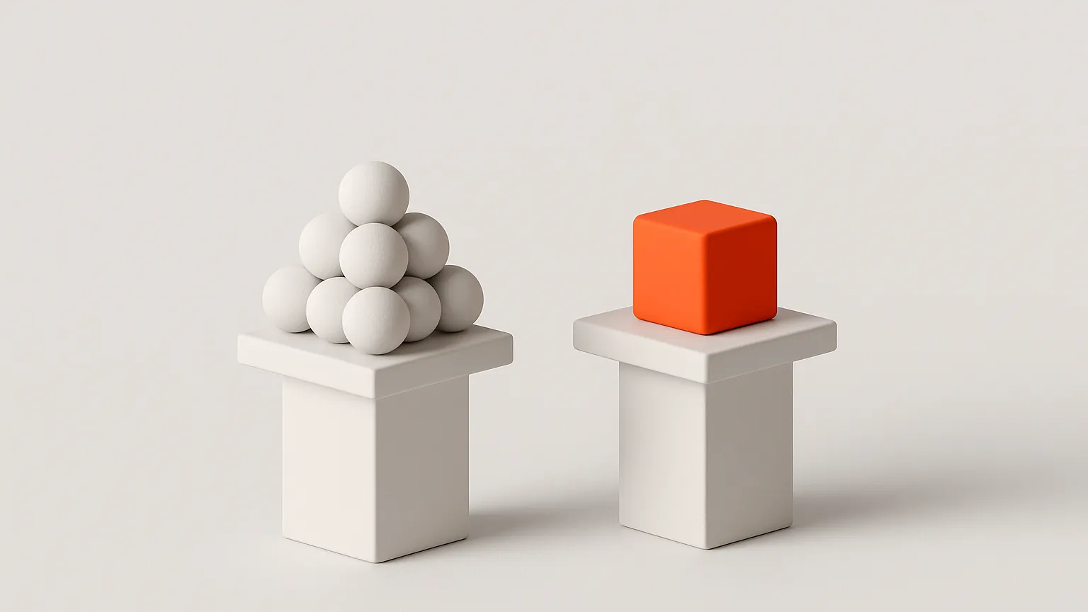 Two white pedestals side by side, one holding small white spheres and one holding an orange cube